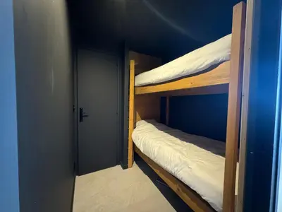 two bunk beds in a blue room with a door at Appartement F2 Bis centre de Megève in Megève