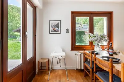 a dining room with a table and a window at Spacieux T3 Parking FREE WIFI Haut-Débit in Magland