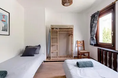 a bedroom with two beds and a window and a shelf at Spacieux T3 Parking FREE WIFI Haut-Débit in Magland