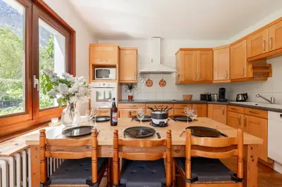 a kitchen with a wooden table and wooden cabinets at Spacieux T3 Parking FREE WIFI Haut-Débit in Magland