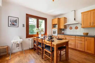 a kitchen with a wooden table and wooden cabinets at Spacieux T3 Parking FREE WIFI Haut-Débit in Magland