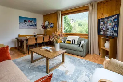 a large patio in front of a building with mountains at Edelweiss 2 Apartment in Chamonix-Mont-Blanc