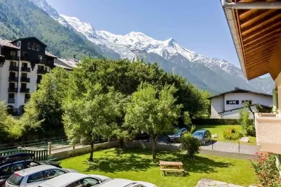 a house in the snow with a bench in the yard at Edelweiss 3 Apartment in Chamonix-Mont-Blanc
