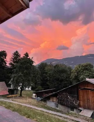 a cloudy sky with a house and trees in a field at Chalet 3 chambres, 11 personnes près du domaine skiable, parking gratuit, Chez Pépé à Saint-Gervais in Saint-Gervais-les-Bains
