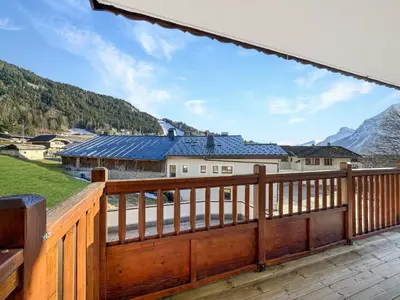 a wooden deck with a view of a mountain at 4 pieces centre village in Les Carroz d'Araches
