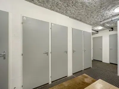 an empty locker room with white doors and a ceiling at 4 pieces centre village in Les Carroz d'Araches
