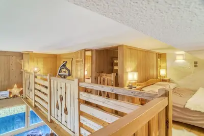 a large bedroom with a bed and a balcony at Le Wood Megève in Megève
