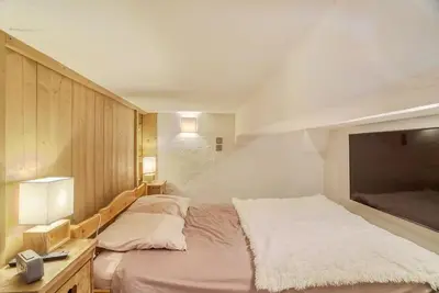 a bedroom with a large bed and a tv at Le Wood Megève in Megève
