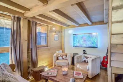 a living room with a table and chairs at Le Wood Megève in Megève