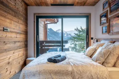 a living room with a table and a large window at Chalet Seven Summits - Pool - Sauna - Jacuzzi - By Cozee Rentals in Chamonix-Mont-Blanc