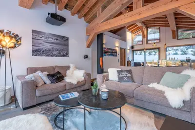 a living room with two couches and a table at Chalet Seven Summits - Pool - Sauna - Jacuzzi - By Cozee Rentals in Chamonix-Mont-Blanc
