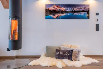 a fireplace in a living room with a fuzzy rug at Chalet Seven Summits - Pool - Sauna - Jacuzzi - By Cozee Rentals in Chamonix-Mont-Blanc