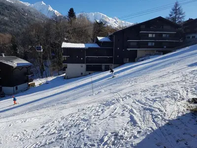 a group of people skiing down a snow covered slope at Etoile des Alpes in Saint-Gervais-les-Bains