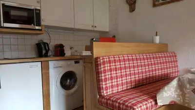 a kitchen with a washing machine with a red towel at Etoile des Alpes in Saint-Gervais-les-Bains