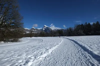 a snow covered road with a mountain in the background at Particulier loue 2 appartements communicants dans chalet à Samoëns jusqu à 16 couchages in Samoëns