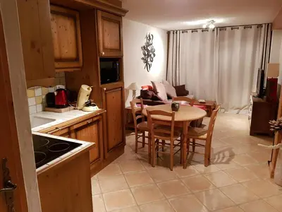 a kitchen with a table and chairs and a couch at Bel appartement au Lays in Arâches-la-Frasse