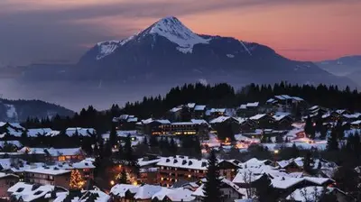 a town covered in snow with a mountain in the background at Bel appartement au Lays in Arâches-la-Frasse