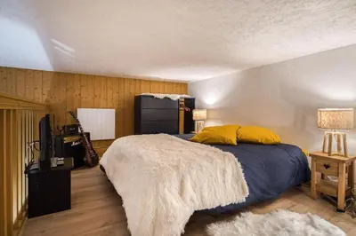 a bedroom with a bed with yellow pillows at Cocoon In Megève in Megève