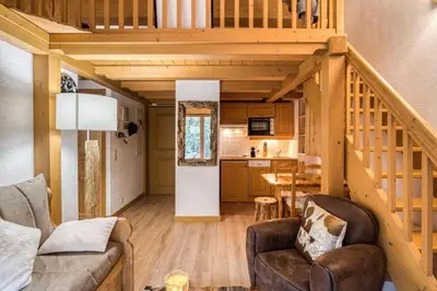a living room with a staircase in a house at Cocoon In Megève in Megève