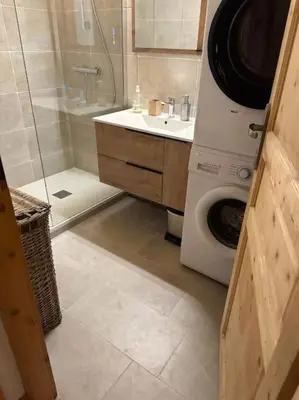 a bathroom with a shower and a washing machine at Cocoon In Megève in Megève