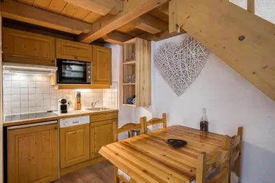 a kitchen with a wooden table and a kitchen with a tableablish at Cocoon In Megève in Megève