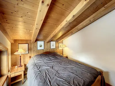 a large bed in a room with wooden ceilings at Appartement 3 pièces proche pistes à Combloux avec parking - FR-1-560-117 in Combloux