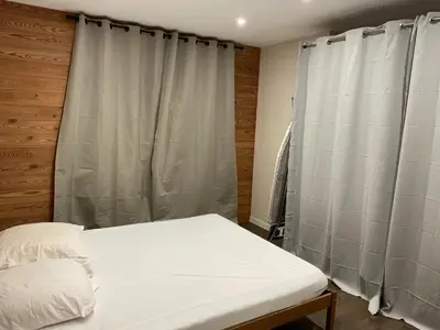 a bedroom with a bed and a window with curtains at Chalet Cristal II in Les Contamines-Montjoie