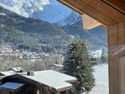 a view of a snowy mountain from a house window at Chalet Cristal II in Les Contamines-Montjoie