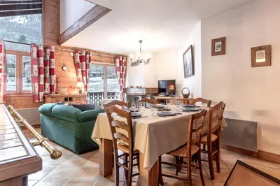 a dining room with a table and a couch at Les Grandes Jorasses - Calme - Duplex in Les Houches