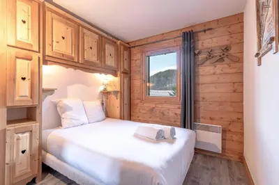 a bedroom with a bed and a window at Les Grandes Jorasses - Calme - Duplex in Les Houches