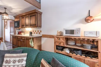 a living room with a couch and a microwave at Les Grandes Jorasses - Calme - Duplex in Les Houches