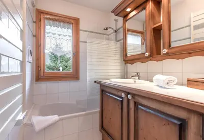 a bathroom with a tub and a sink and a bath tubermottermott at Les Grandes Jorasses - Calme - Duplex in Les Houches
