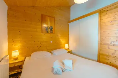 a bedroom with a bed with two towels on it at 3 chambres - Plan des Reines - 356 - Happy Rentals in Chamonix-Mont-Blanc