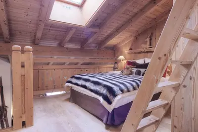 a bedroom with a bunk bed in a log cabin at Duplex Chaleureux au Cœur de Megève 2 p in Megève