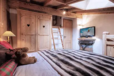 a teddy bear sitting on a bed in a bedroom at Duplex Chaleureux au Cœur de Megève 2 p in Megève