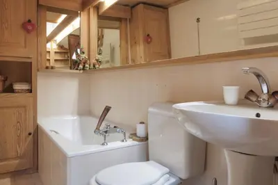 a bathroom with a sink and a toilet and a mirror at Duplex Chaleureux au Cœur de Megève 2 p in Megève