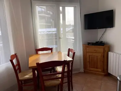 a dining room with a table and chairs and a television at Resort central apartment ideal for up to 2 people in Les Carroz d'Araches