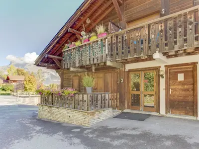 a wooden house with a balcony with flowers on it at Apartment Les Grets-9 by Interhome in Saint-Gervais-les-Bains