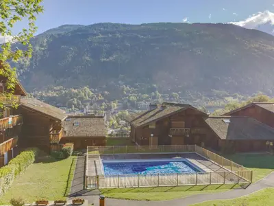 a wooden house with a balcony and flowers on it at Apartment Les Grets-9 by Interhome in Saint-Gervais-les-Bains