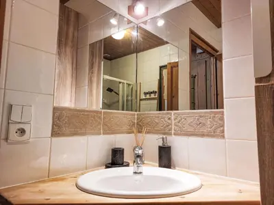a white bathroom with a sink and a mirror at Apartment Le clos Alpin by Interhome in Saint-Gervais-les-Bains