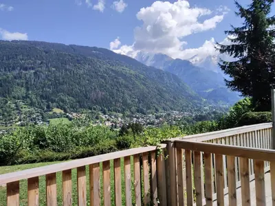 a table on a deck with a view of mountains at Apartment Le clos Alpin by Interhome in Saint-Gervais-les-Bains