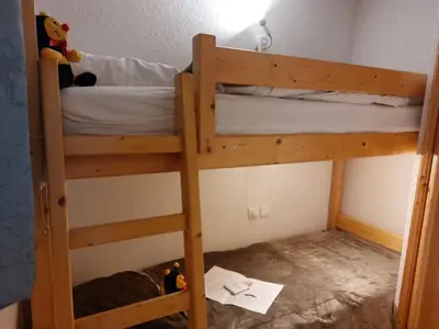 a stuffed teddy bear sitting on a bed with papers at Apartment Jardins Alpins 2 by Interhome in Saint-Gervais-les-Bains