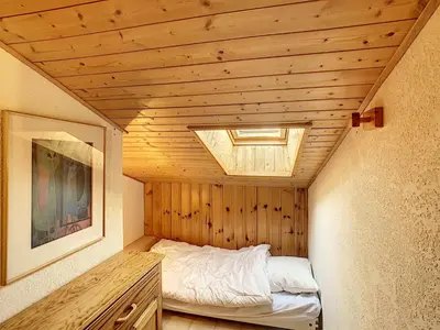 a small bedroom with a bed in a wooden ceiling at Duplex 3 pièces au cœur de Combloux, proche navette ski, balcon Mont Blanc, parking et casier à skis - FR-1-560-120 in Combloux