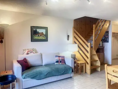 a living room with a couch and a staircase at Duplex 3 pièces au cœur de Combloux, proche navette ski, balcon Mont Blanc, parking et casier à skis - FR-1-560-120 in Combloux
