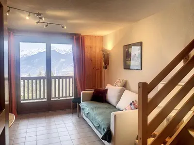 a living room with a couch and a sliding glass door at Duplex 3 pièces au cœur de Combloux, proche navette ski, balcon Mont Blanc, parking et casier à skis - FR-1-560-120 in Combloux