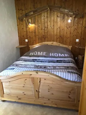a wooden bed in a room with a wooden wall at Princesse jonquille in Demi-Quartier
