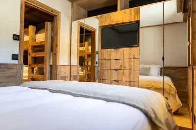 a bedroom with two beds and a flat screen tv at Apartment with terrace and parking heart of Megève in Megève