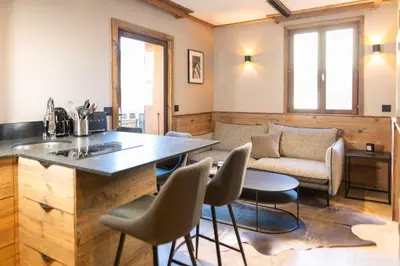 a living room with a table and chairs and a couch at Apartment with terrace and parking heart of Megève in Megève