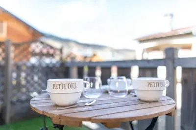 a wooden table with two cups and glasses on it at Apartment with terrace and parking heart of Megève in Megève