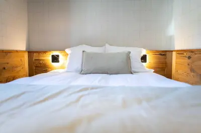 a large white bed with a pillow on it at Apartment with terrace and parking heart of Megève in Megève